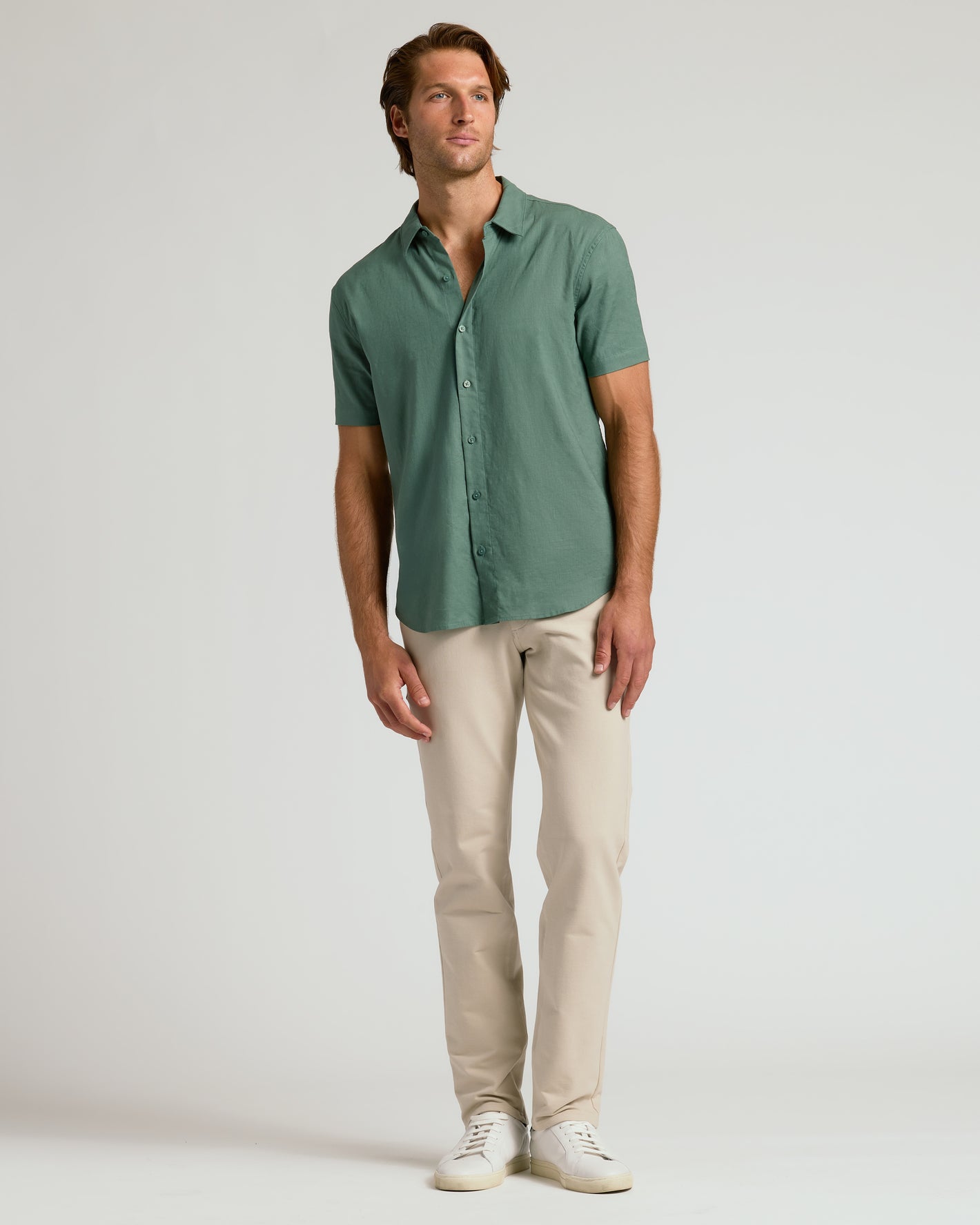 Man modeling Moss Short Sleeve Linen Shirt with beige trousers and white sneakers.