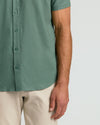 Moss Short Sleeve Linen Shirt worn with beige trousers.