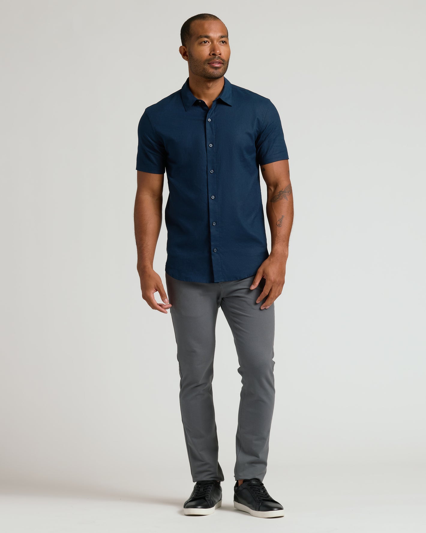 Male model wearing Navy Short Sleeve Linen Shirt and slim-fit trousers.