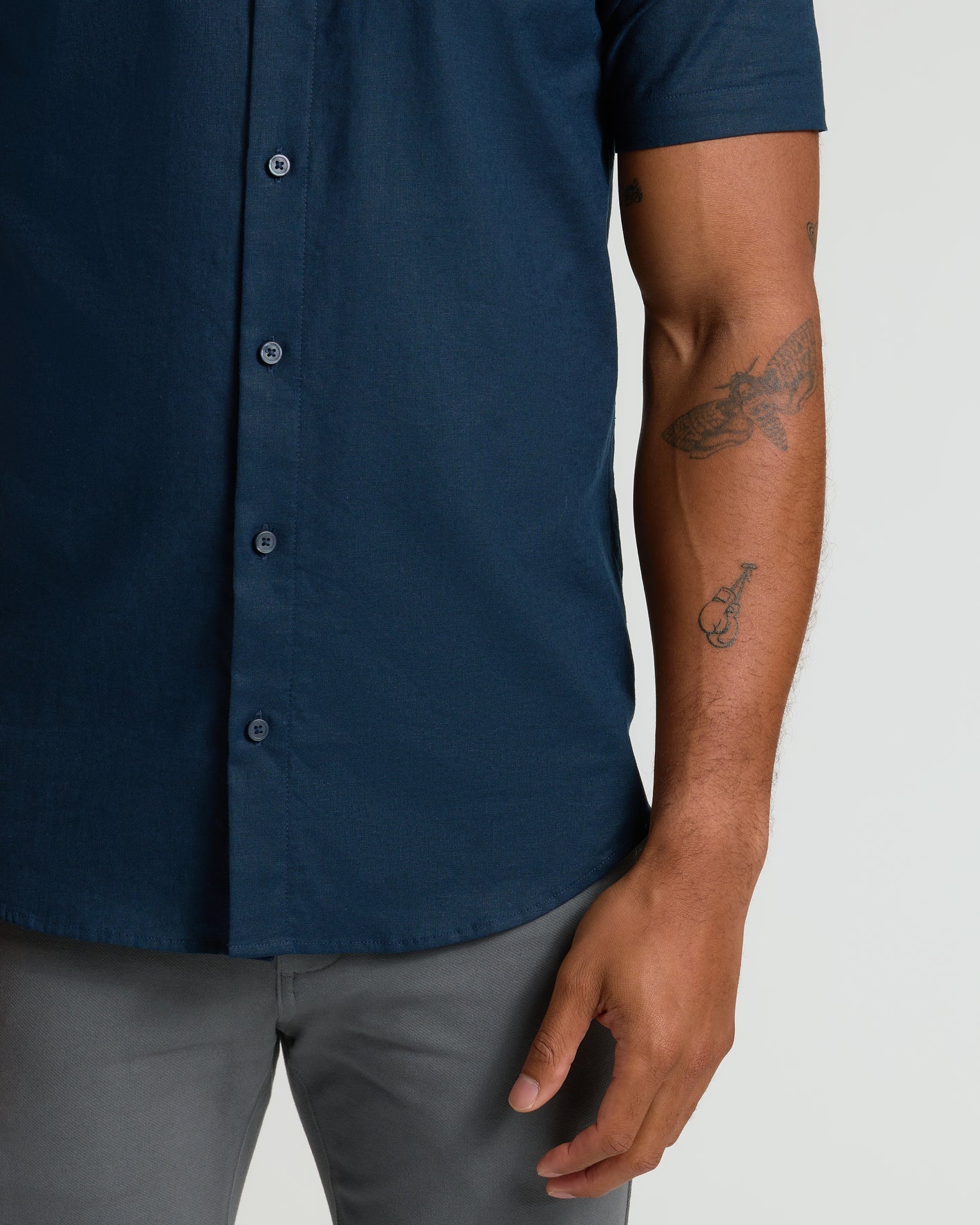 Navy Short Sleeve Linen Shirt worn with gray pants, showcasing arm tattoos.