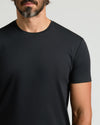 Close-up of a man wearing a black crew neck t-shirt, showcasing the smooth fabric and curved hem style of the Pima Cotton Blend Curved Hem Crew 7-Pack, a mens basics essential.