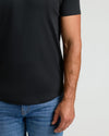 Close-up of a man wearing a black crew neck t-shirt with a curved hem, paired with blue jeans, showcasing the Pima Cotton Blend Curved Hem Crew 7-Pack men's basics style.
