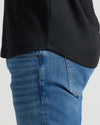 Close-up of the curved hem detail on a black Pima Cotton Blend Curved Hem Crew 7-Pack shirt worn with blue jeans, highlighting the smooth fabric and casual fit.