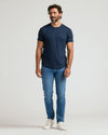 Man wearing a navy crew neck t-shirt with curved hem paired with blue jeans and white sneakers, showcasing the Pima Cotton Blend Curved Hem Crew 4-Pack men's basics.