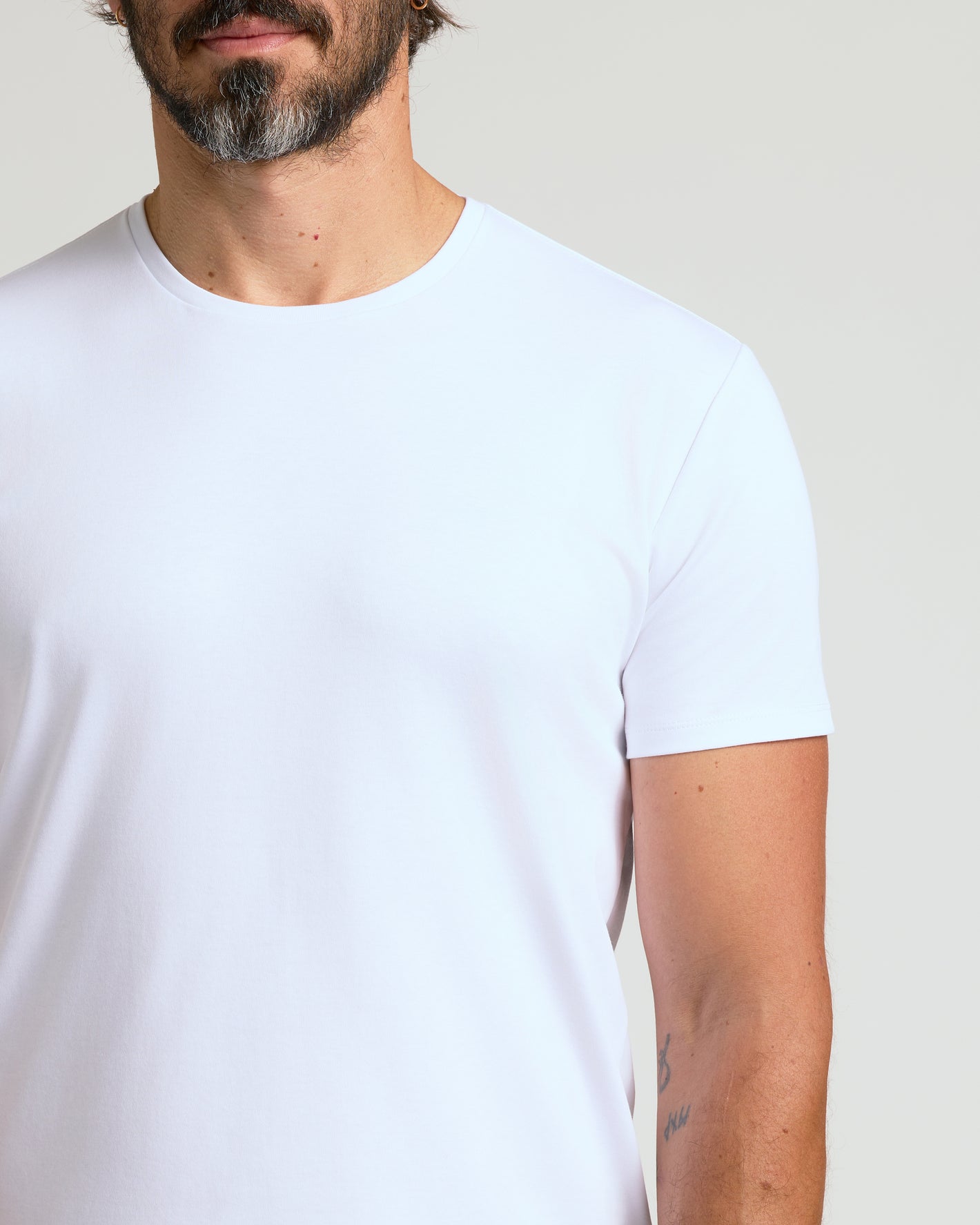White Premium Pima Crew Curved Hem, snug fit, visible tattoo.