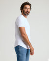 Man in White Premium Pima Crew Curved Hem T-shirt, side view.