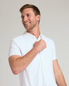 Man wearing White Short Sleeve Comfort Knit Shirt, adjusting front.