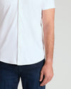 White Short Sleeve Comfort Knit Shirt with dark blue jeans, right arm visible.