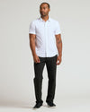 Man in All White Short Sleeve Performance Dress Shirt, black trousers.