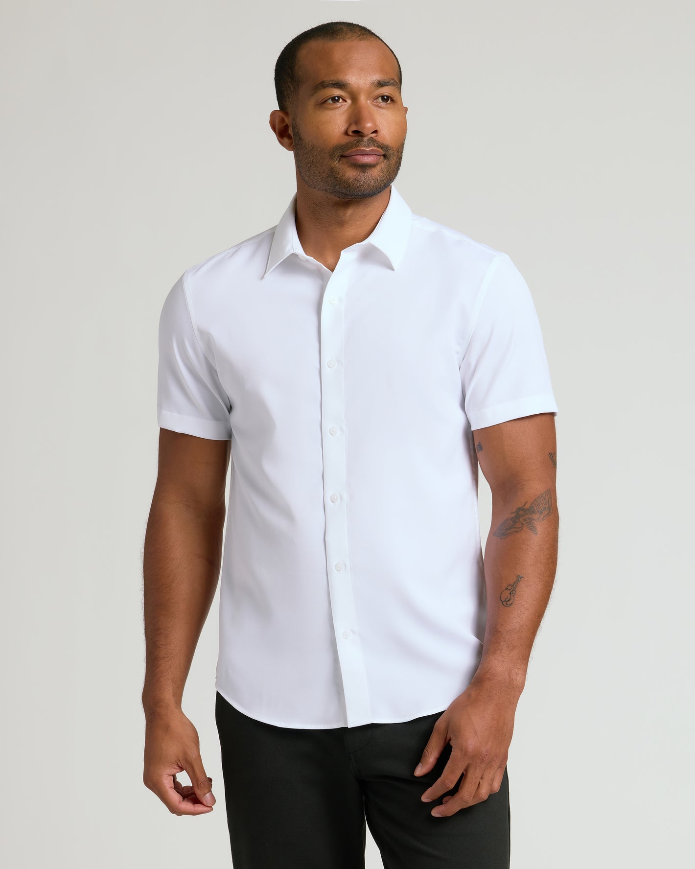 Man wearing All White Short Sleeve Performance Dress Shirt, showcasing tattoos.