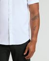 White Performance Dress Shirt tucked into black trousers, showcasing tattoos.