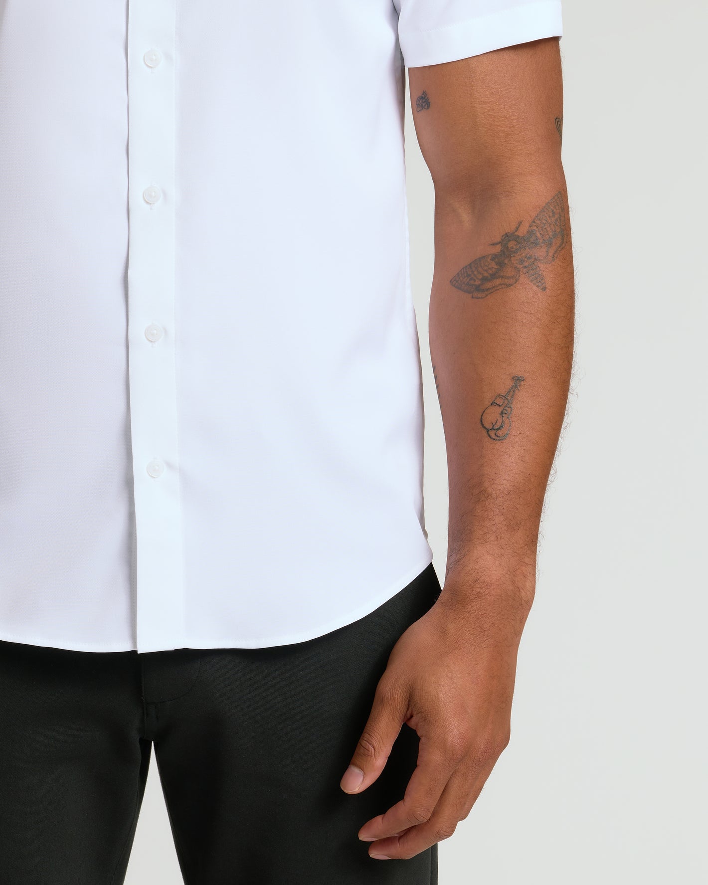 White Performance Dress Shirt tucked into black trousers, showcasing tattoos.