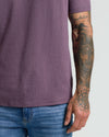 Dark Heather Plum Classic V-Neck, showcasing tattoos on right forearm.