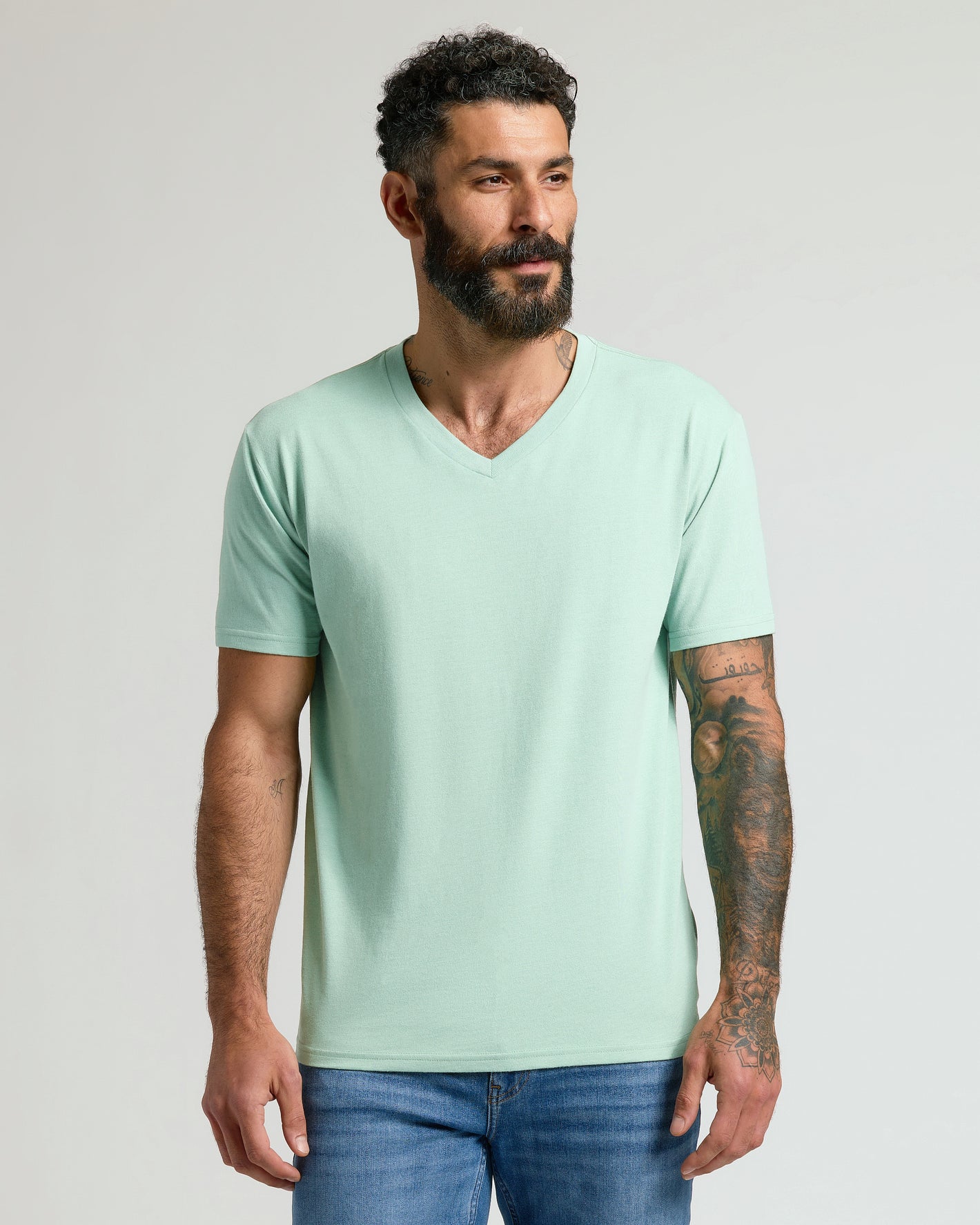 Heather Mist Classic V-Neck on tattooed model in blue jeans.