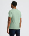 Person wearing a light green t-shirt on a white background