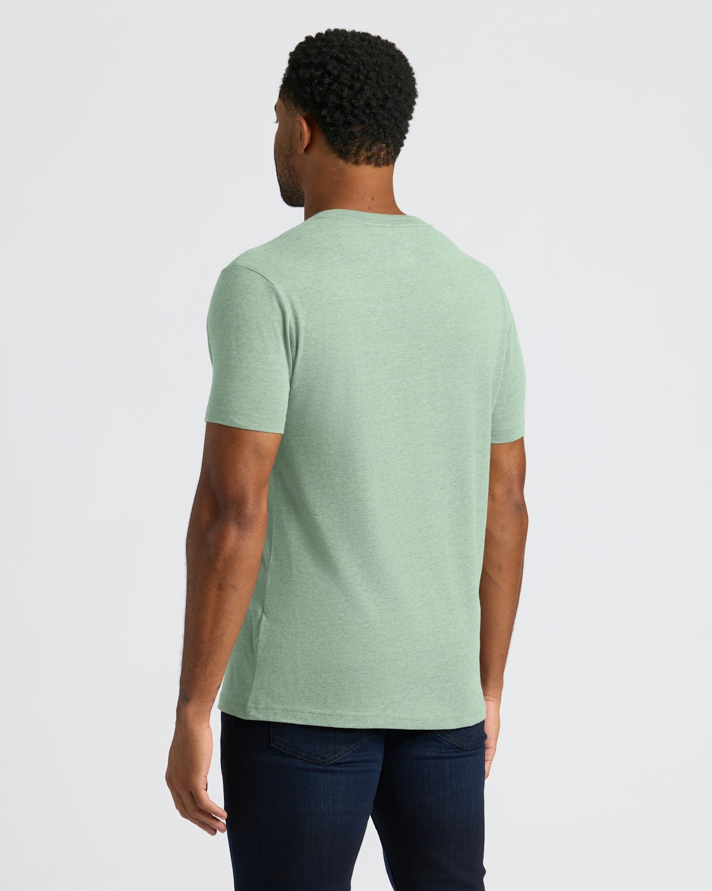 Person wearing a light green t-shirt on a white background