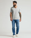 Man wearing Steel Classic V-Neck, blue jeans, and white sneakers.