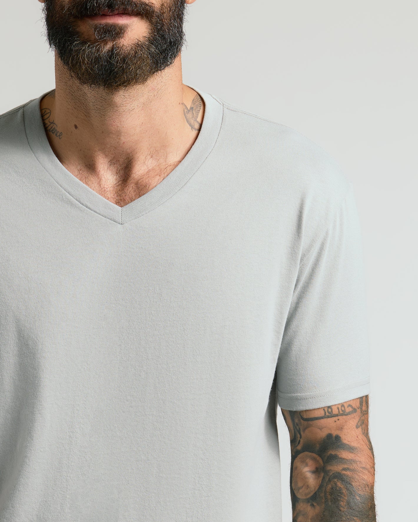 Steel Classic V-Neck on bearded man, showcasing tattoos and fit.