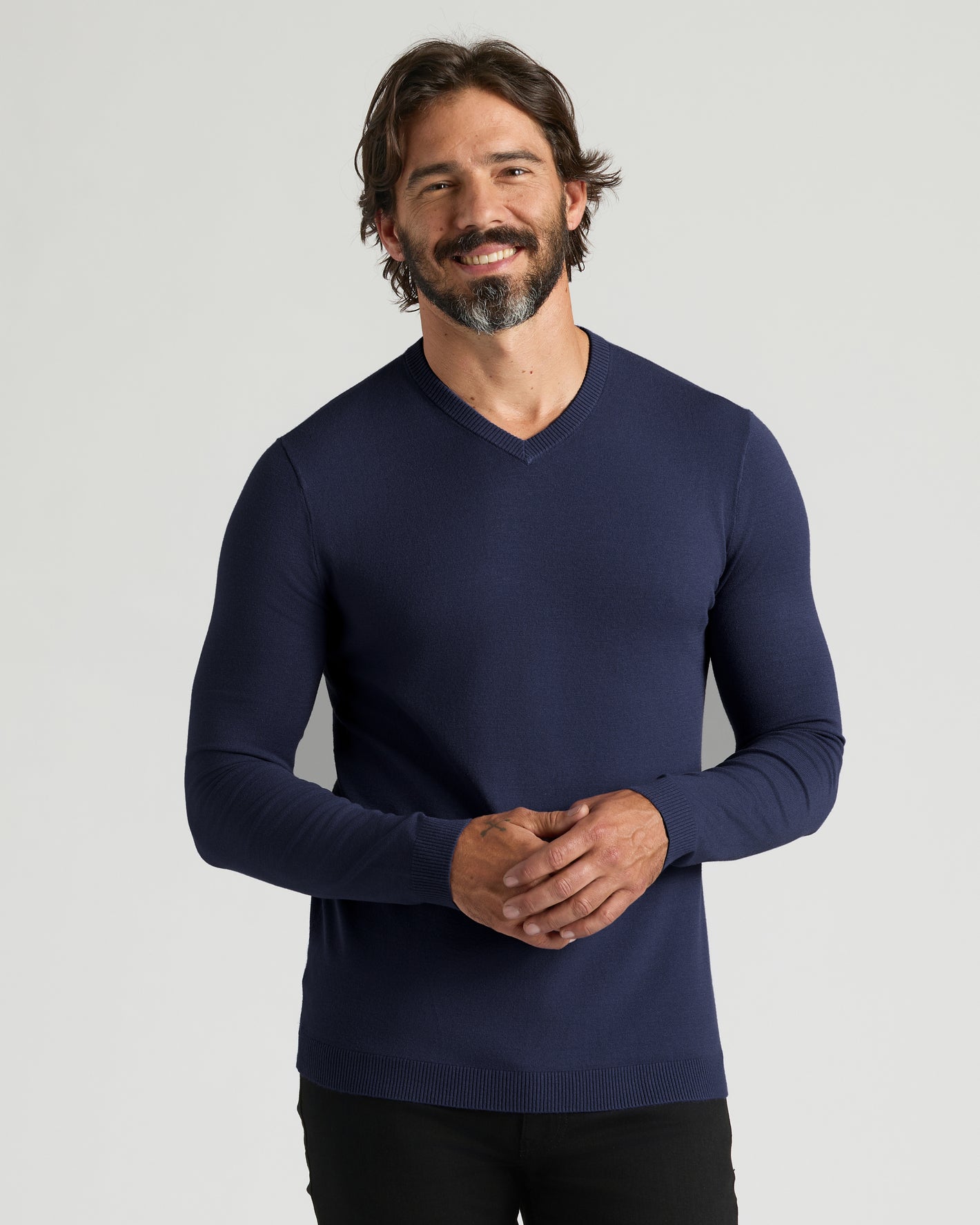 Man in Navy Dressy V-Neck Sweater smiling, arms clasped.