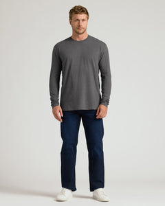 True ClassicA man modeling a dark gray long-sleeve crewneck shirt, dark blue jeans, and white sneakers against a light gray studio background.
