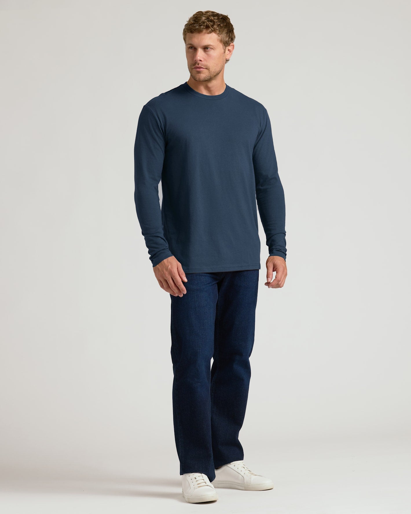 Man wearing Classic Long Sleeve Crew Neck 6-Pack, navy shirt and dark jeans.