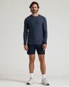 Man wearing a Dark Heather Fiord Active Long Sleeve Crew T-Shirt with navy shorts and white sneakers against a plain background, showcasing men's basics.