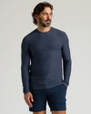 Man wearing a Dark Heather Fiord Active Long Sleeve Crew T-Shirt with navy shorts, posing against a plain light background in a casual style.