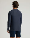 Man wearing a Dark Heather Fiord Active Long Sleeve Crew T-Shirt shown from the back, paired with dark athletic shorts, against a plain light background.