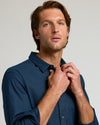 Young man buttoning Navy Long Sleeve Linen Shirt.