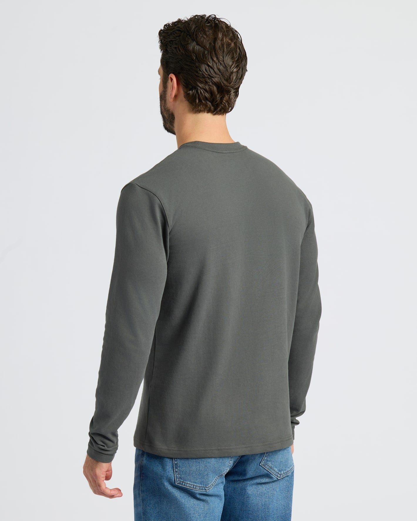Man wearing Carbon Heavyweight Long Sleeve Pocket Crew, highlighting back fit.