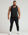Man wearing Sleeveless Active Mesh Tank 3-Pack with joggers and running shoes.