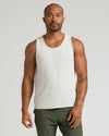 Man wearing The Standard Sleeveless Active Mesh Tank, showcasing tattoos and relaxed posture.
