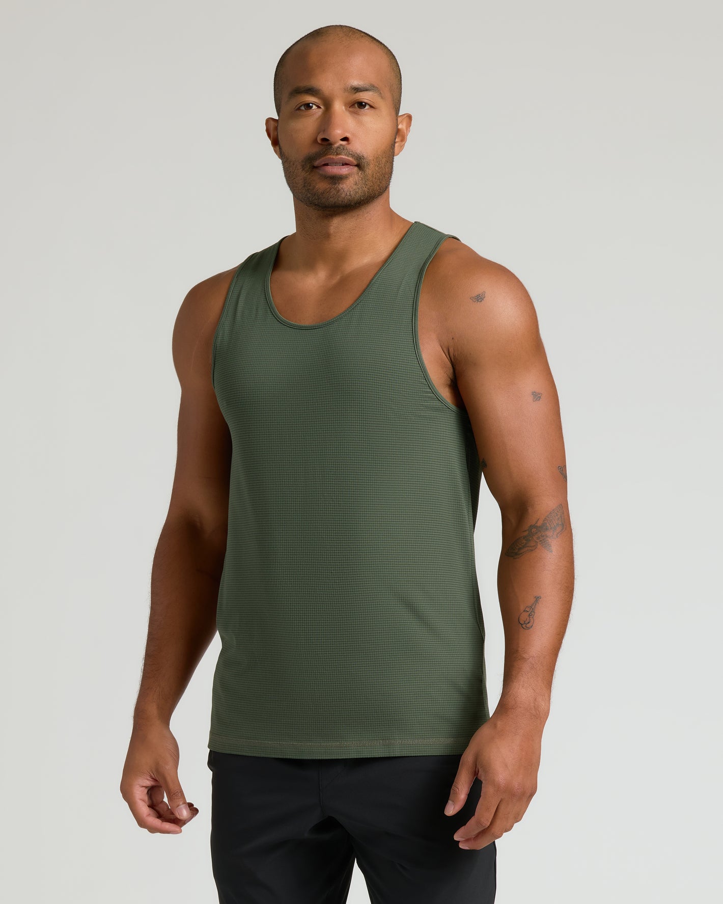 Model wearing Sleeveless Active Mesh Tank, olive-green, showcasing athletic fit and texture.