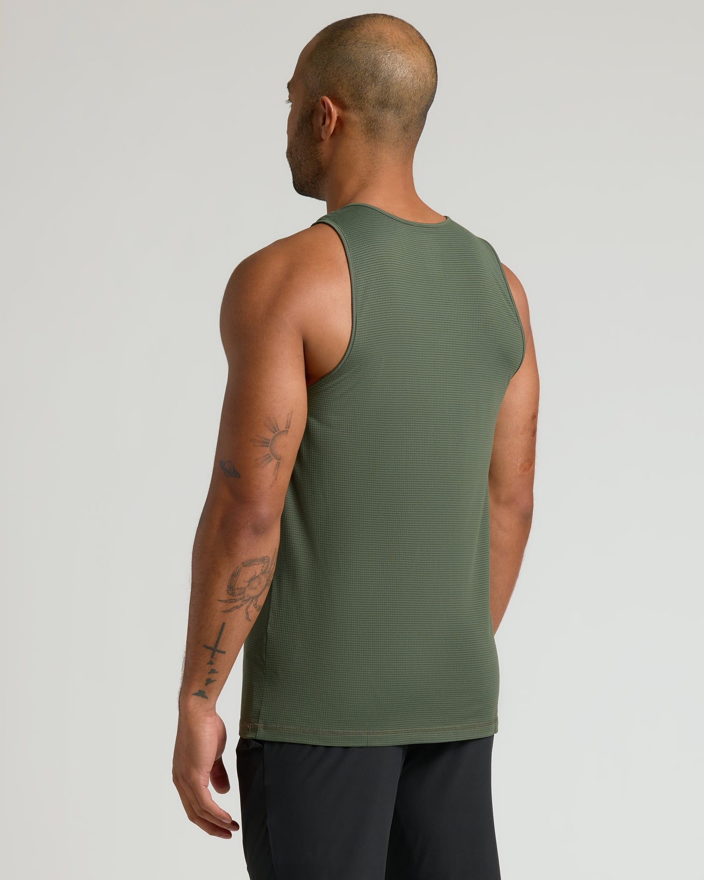 Man wearing the Sleeveless Active Mesh Tank in olive green, back view.