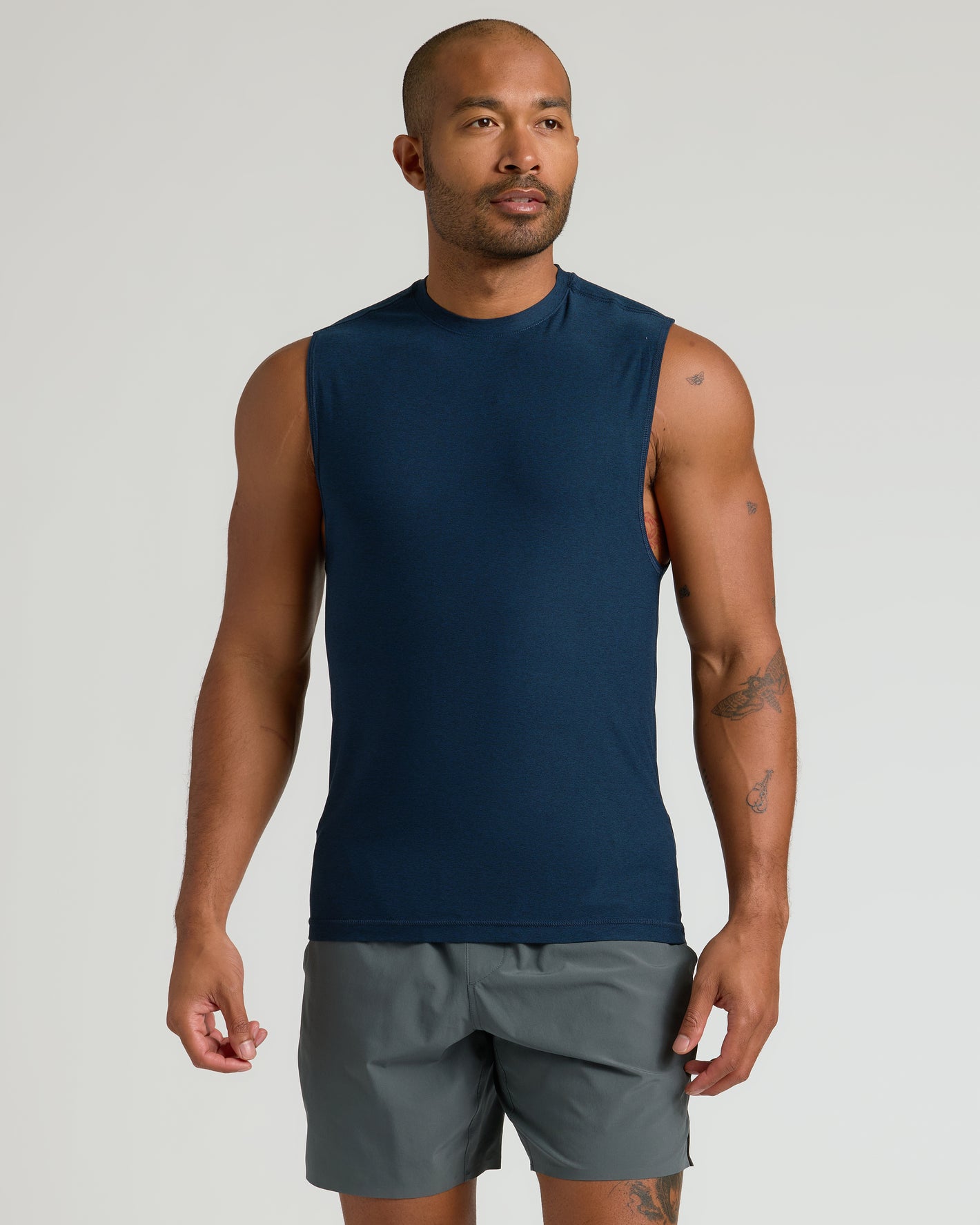 Model wearing The Timeless Sleeveless Active Muscle Tee in navy, showcasing athletic fit.