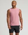 Man in Quartz Rose Sleeveless Active Muscle Tee, showcasing tattoos and neutral expression.