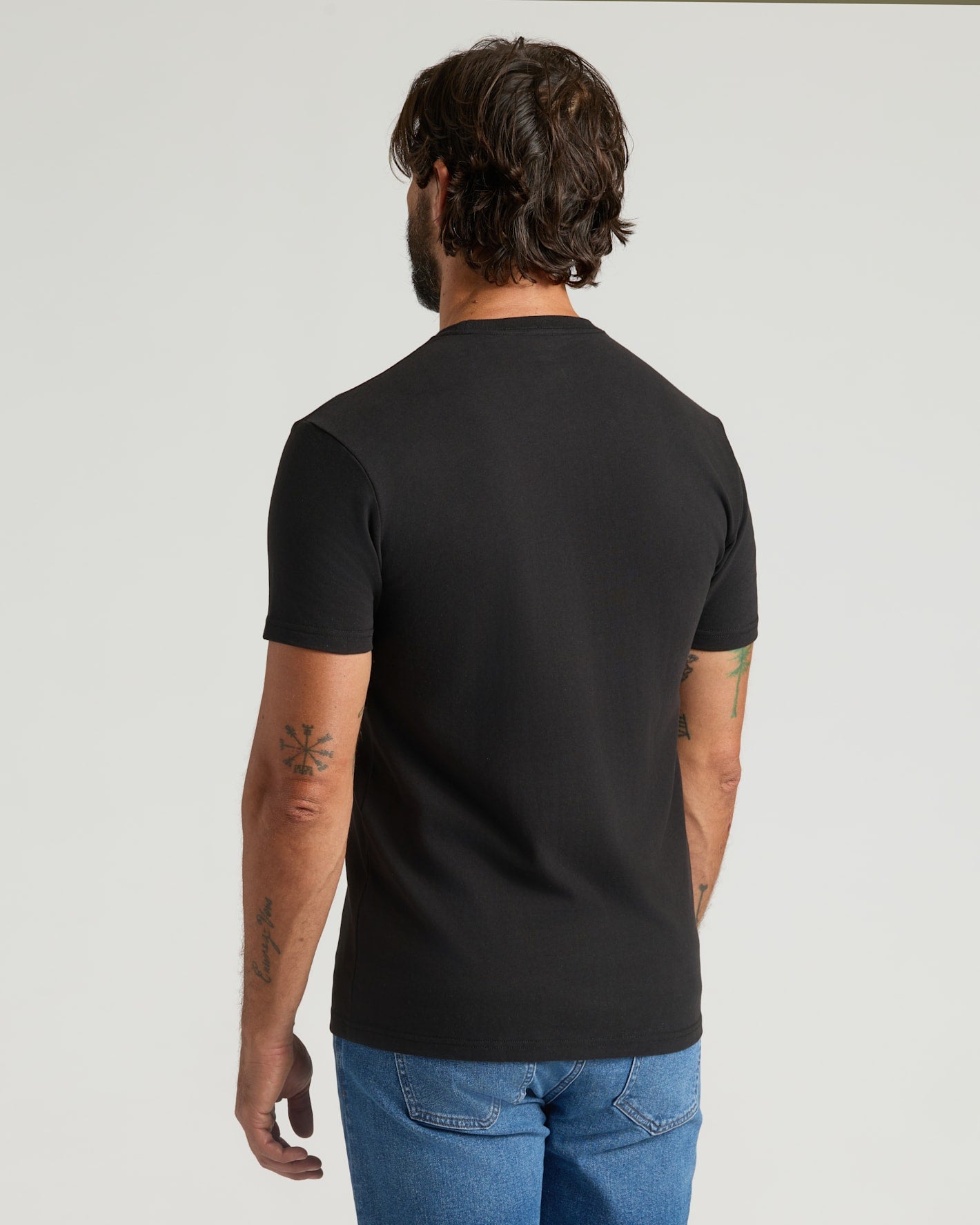 Black Heavyweight Pocket Crew rear view, worn by tattooed man in jeans.