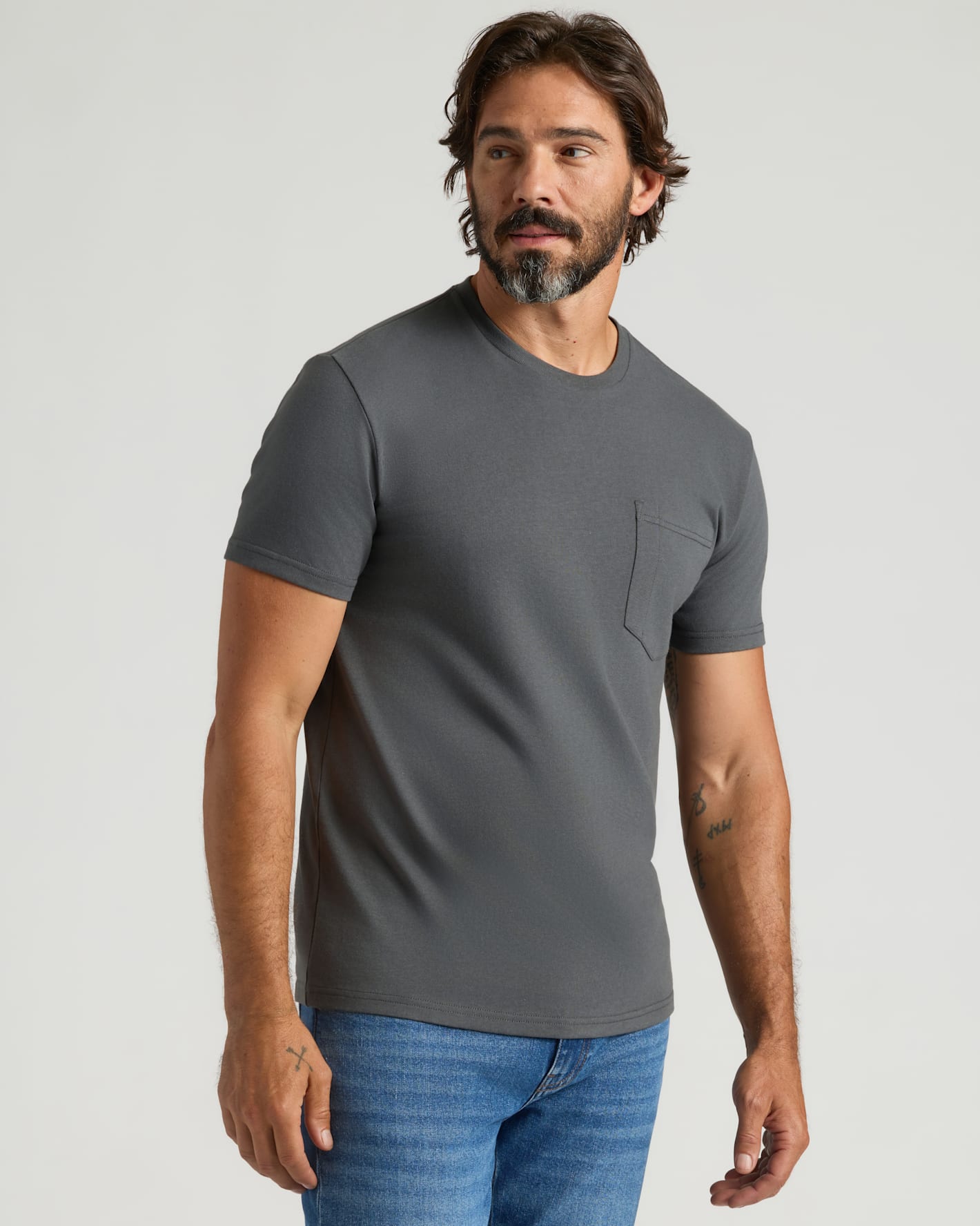 Man in Staple Heavyweight Pocket Crew, charcoal-gray, with jeans.