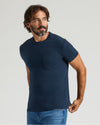 Man models Navy Heavyweight Pocket Crew T-shirt with jeans.