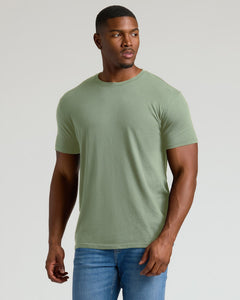 True ClassicMan wearing a green t-shirt and blue jeans against a plain background