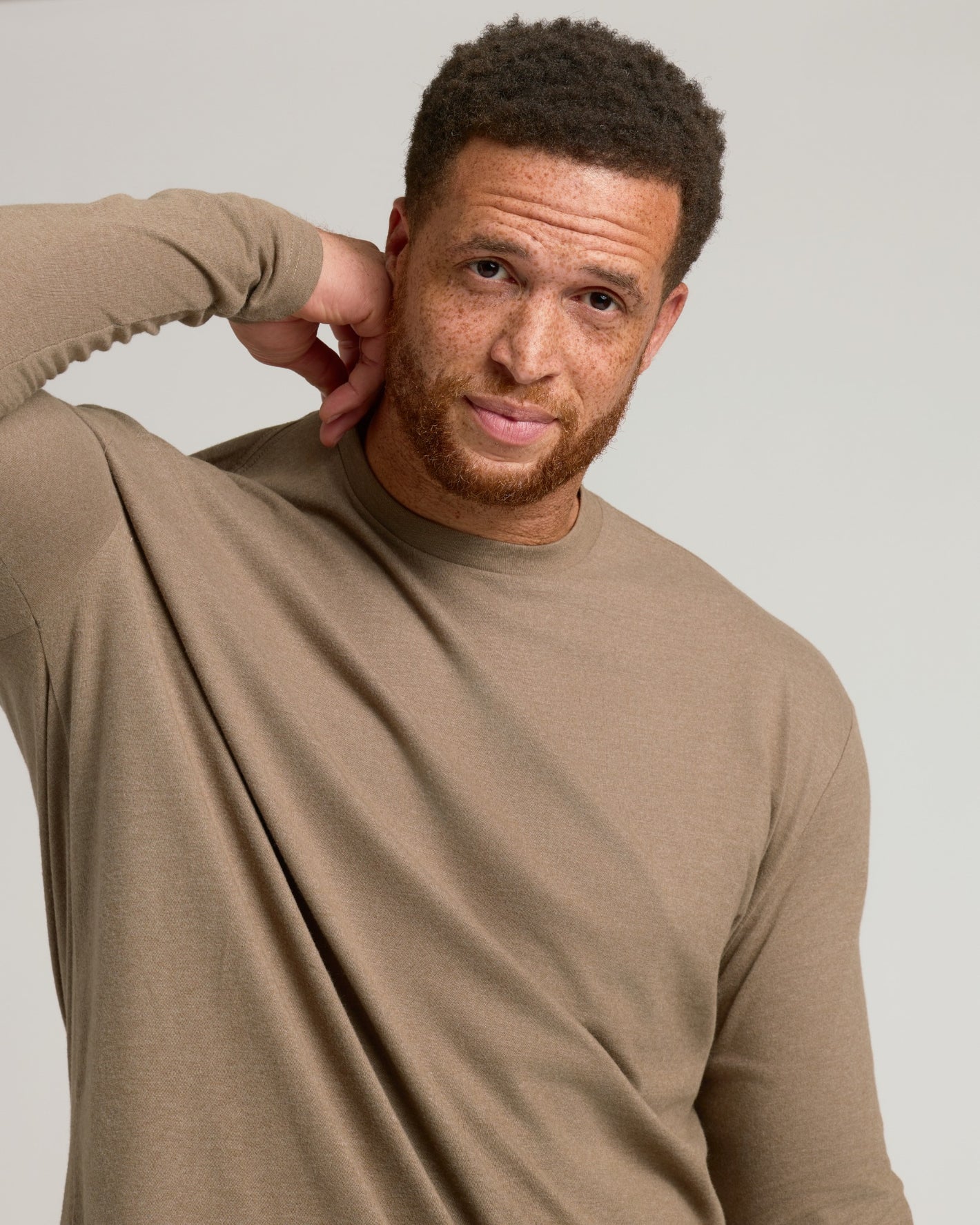 Man wearing Dark Heather Sagewood Tall Long Sleeve T-Shirt, relaxed expression.