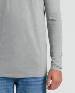 True ClassicClose-up of a person wearing a light heather gray long-sleeve top with blue jeans against a plain light gray background.