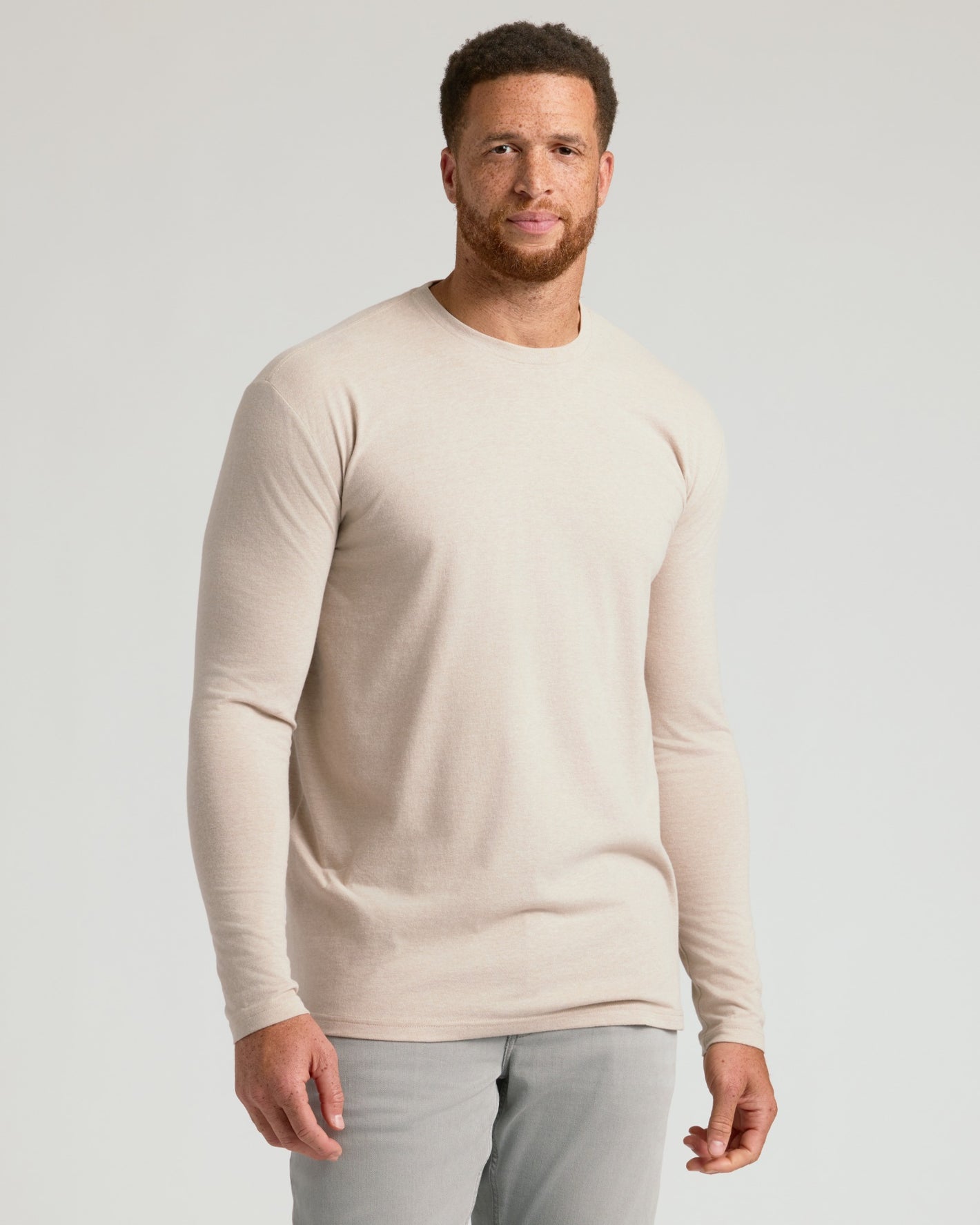 Man wears Seasonal Tall Classic Long Sleeve Crew, beige, with gray pants.