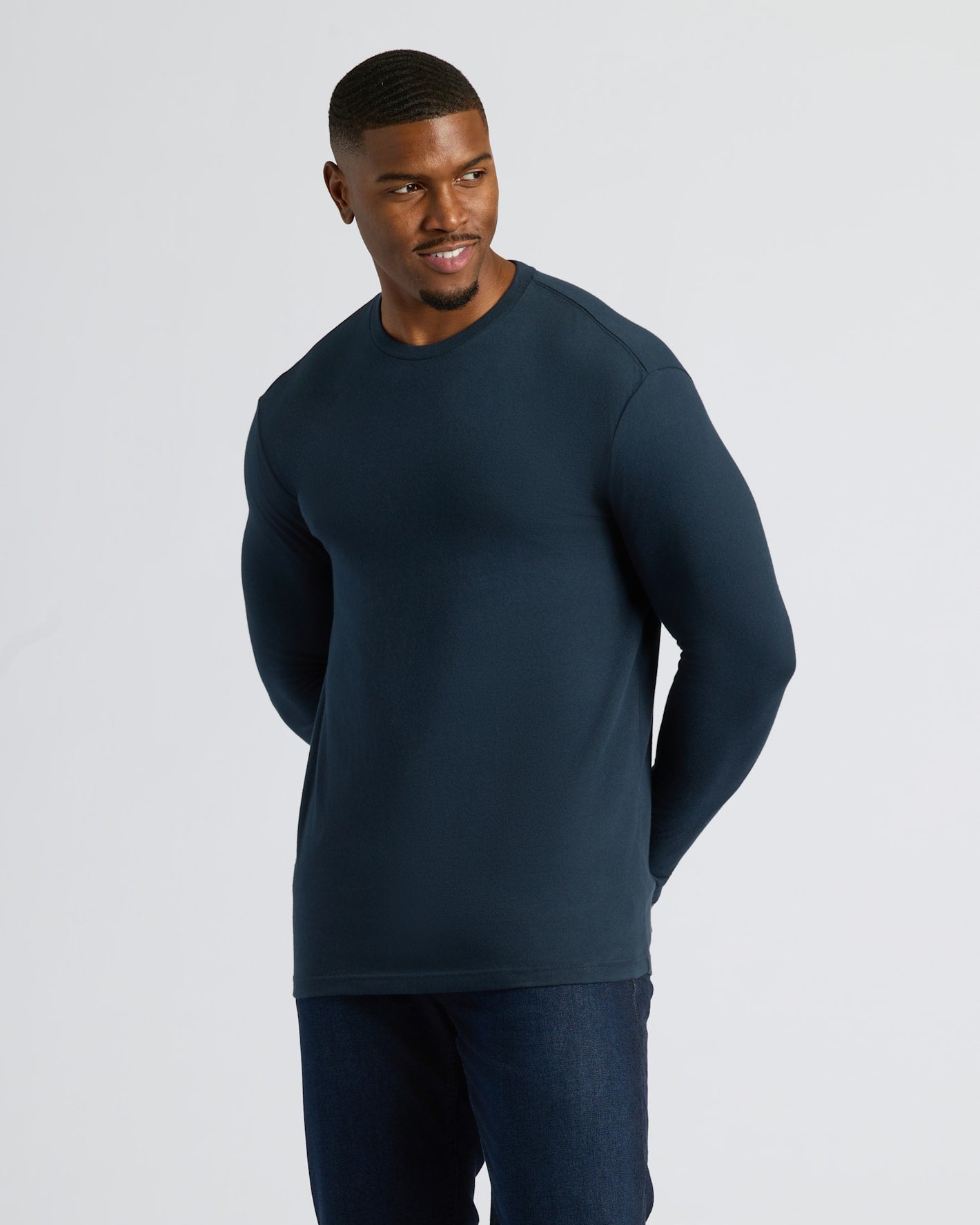 Man in Navy Tall Long Sleeve T-Shirt and dark jeans.