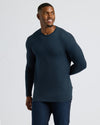 Man wearing a dark blue long-sleeve shirt against a light gray background