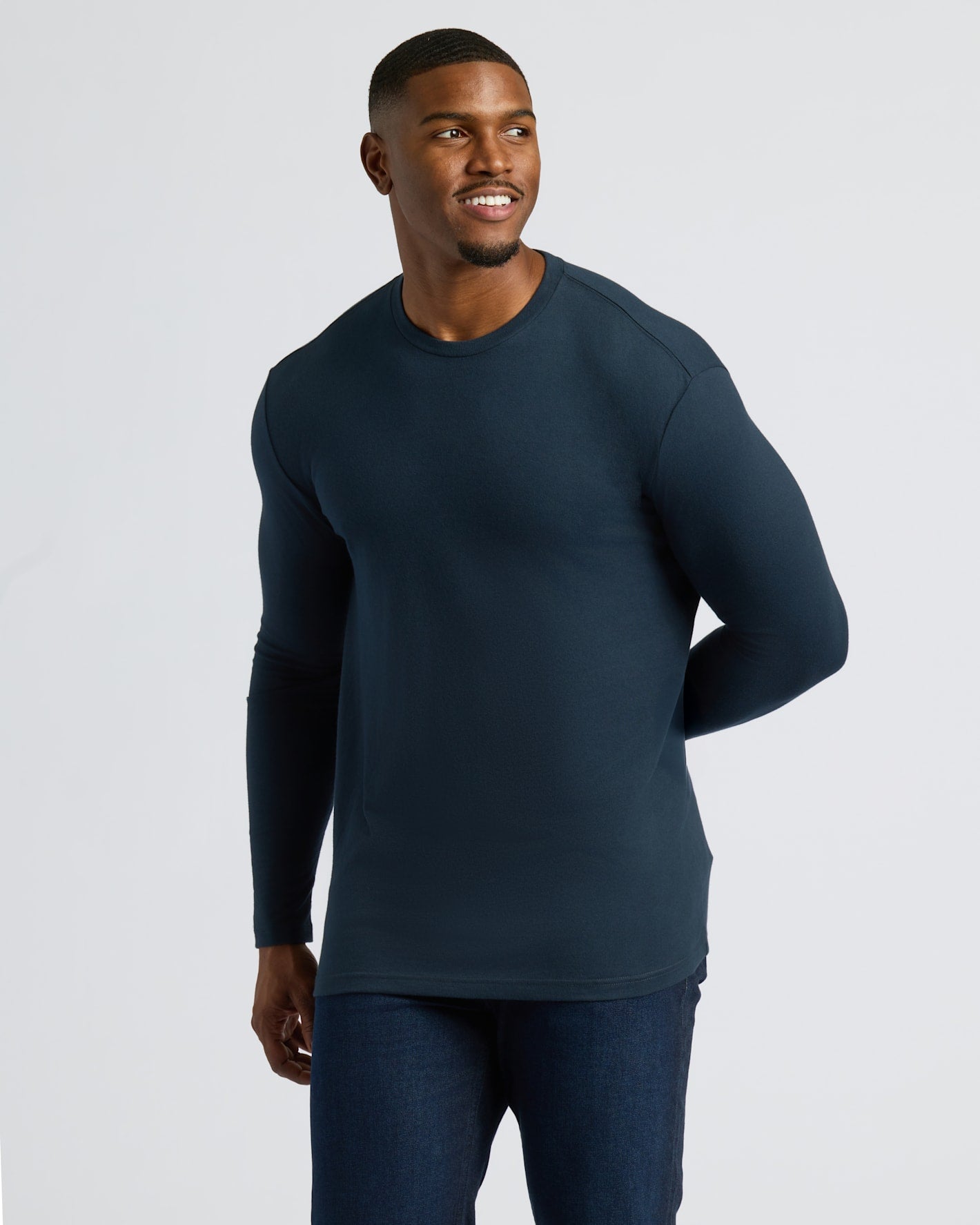 Man wearing a dark blue long-sleeve shirt against a light gray background