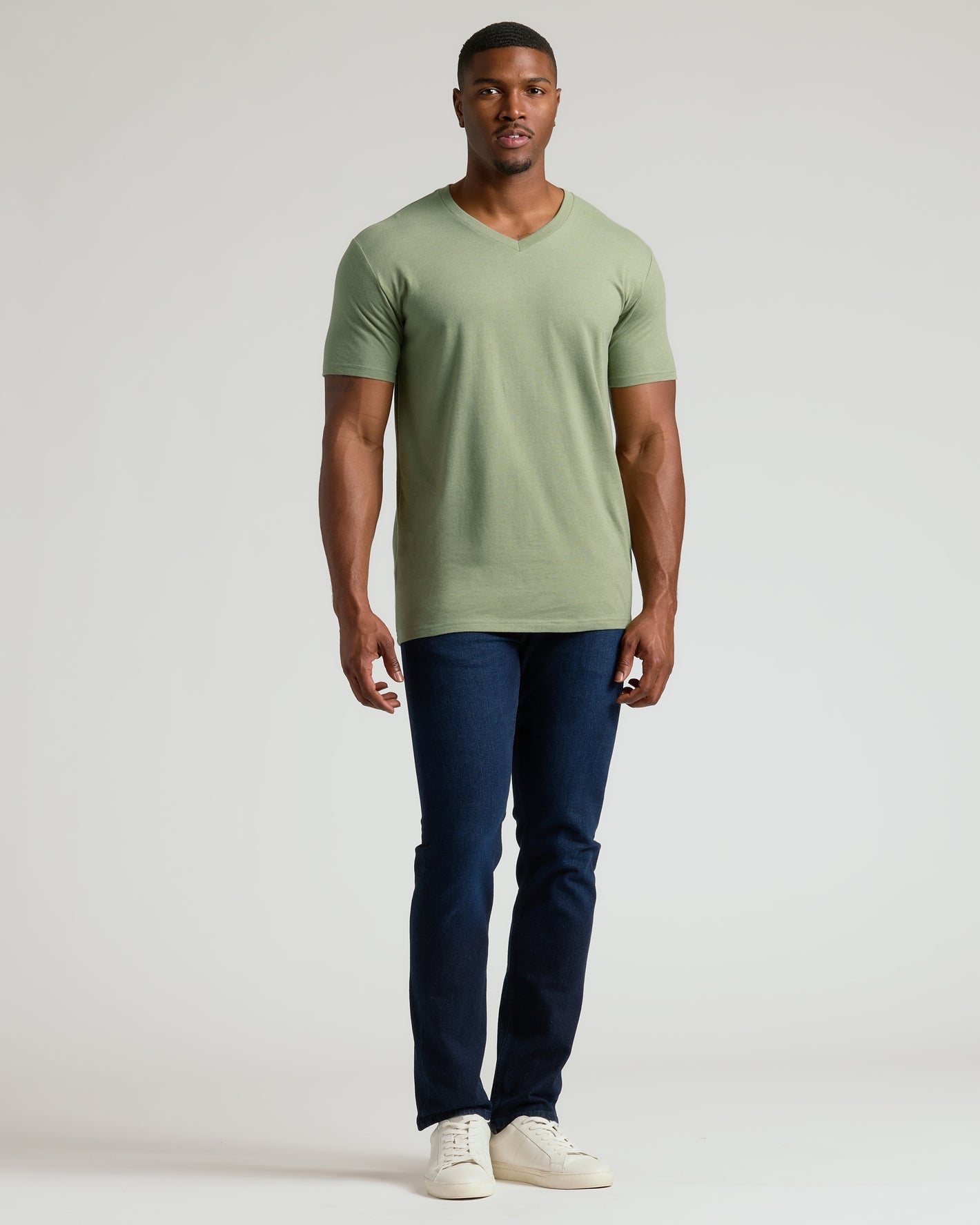 Man in Dark Heather Bay Green Tall Classic V-Neck, slim-fit jeans, sneakers.
