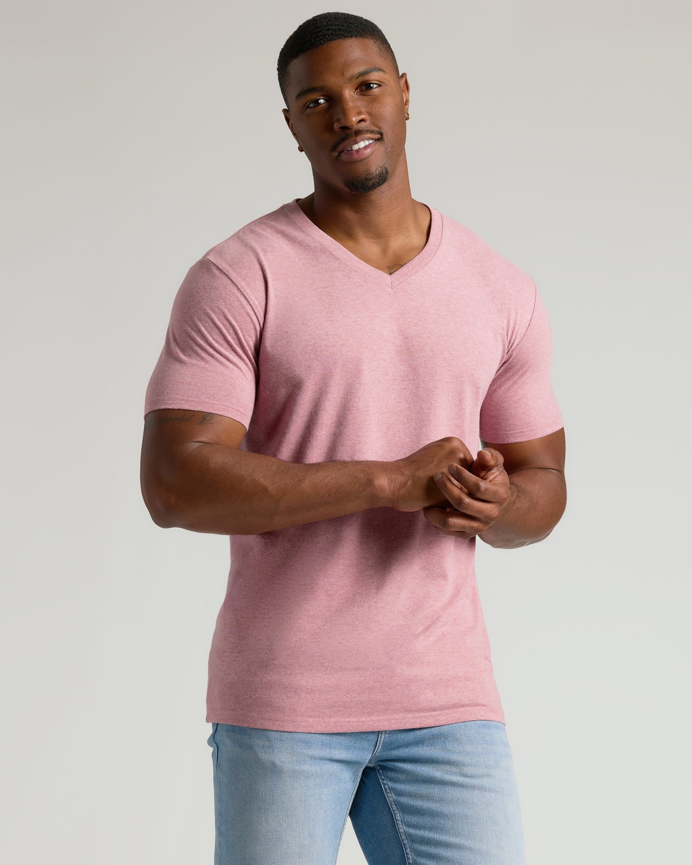 Man in Seasonal Tall Classic V-Neck, pink, light-wash jeans.