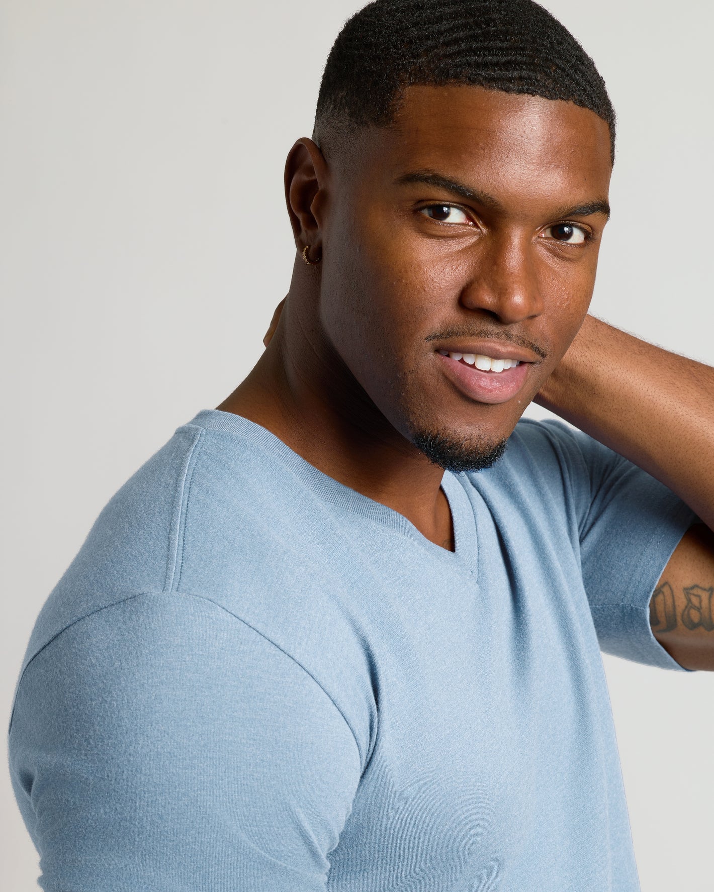 Heather Indigo Tall Short Sleeve Classic V-Neck on young man, tattoo visible.