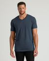Man wearing a dark blue t-shirt against a gray background